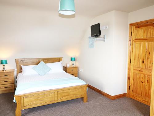 um quarto com uma cama e uma televisão na parede em Tullyally em Red Castle
