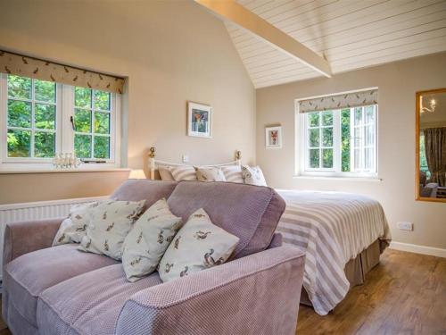 a bedroom with a bed and a couch and windows at Lime Tree in Burford