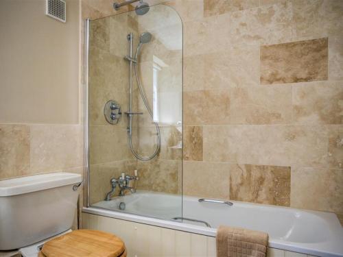 a bathroom with a shower and a toilet and a tub at Lime Tree in Burford