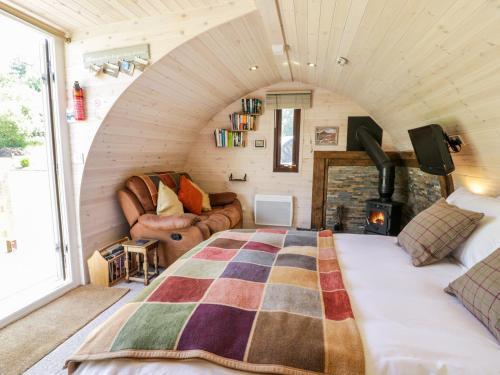 um quarto com uma cama e uma lareira num quarto em Idris Pod em Tremeirchion
