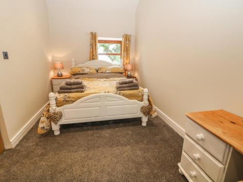 a bedroom with two beds and a mirror at Y Deri Cottage in Llandwrog