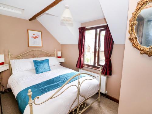 a bedroom with a bed and a mirror at Beech Cottage in Llanidloes