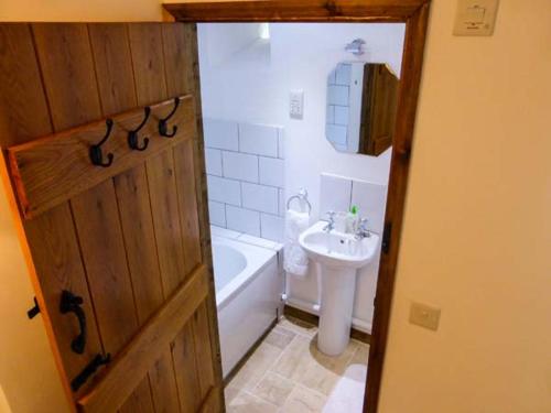a bathroom with a sink and a tub and a toilet at The Old Cottage in Weston-super-Mare