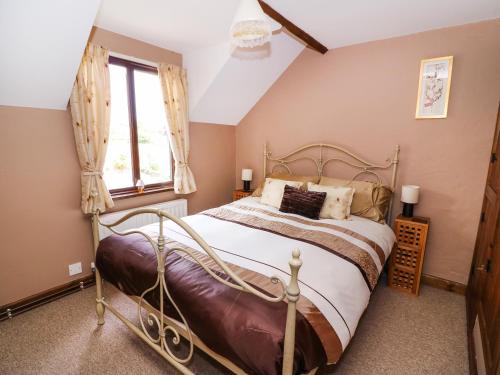 a bedroom with a bed and a window at Oak Cottage in Llanidloes