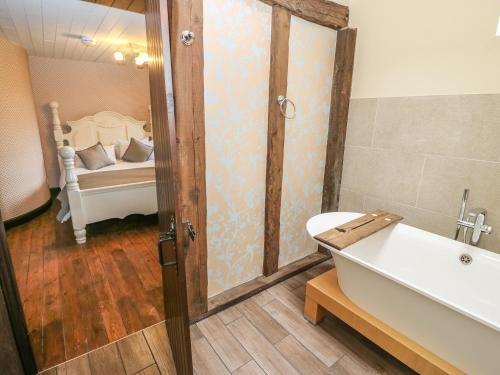 a bathroom with a tub and a bed in a room at The Long View in Hebden Bridge