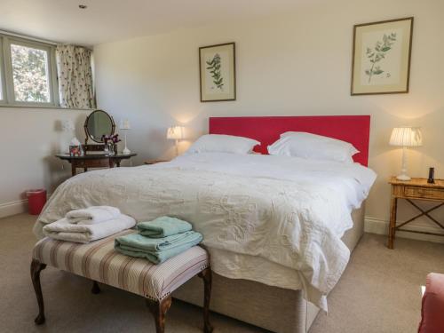 a bedroom with a large bed with towels on a bench at Cow Byre in Great Habton