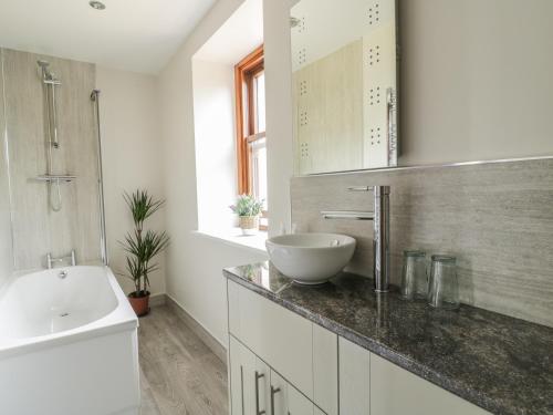 a bathroom with a sink and a bath tub at 1 Leesrigg Cottages in Wigton