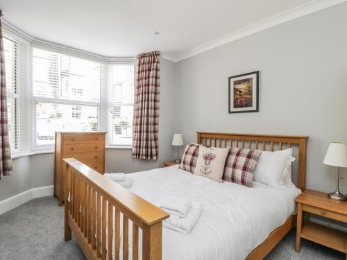 a bedroom with a bed and two windows at Ivy Bank in Windermere