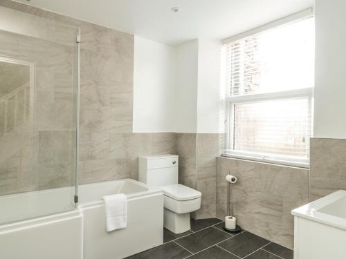a bathroom with a tub and a toilet and a sink at Ivy Bank in Windermere
