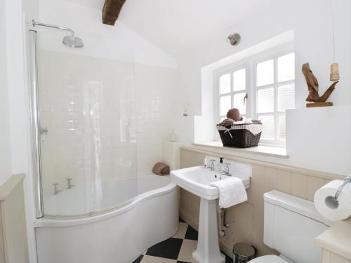 a white bathroom with a tub and a sink at Blenheim Edge, The Causeway in Woodstock