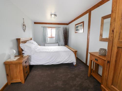 a bedroom with a bed with white sheets and a window at Shepherd's View in Meadowtown