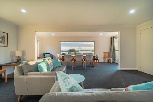 a living room with couches and a table and chairs at Umtali Beach House in Bridport