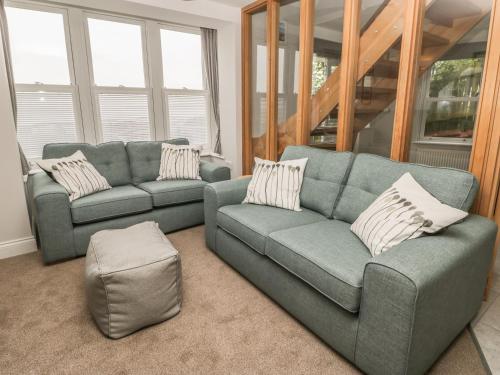 a living room with two couches and a stool at Sunrise in Filey