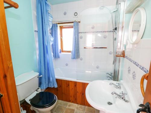 a bathroom with a tub and a sink and a toilet at Rose Cottage in Great Edston