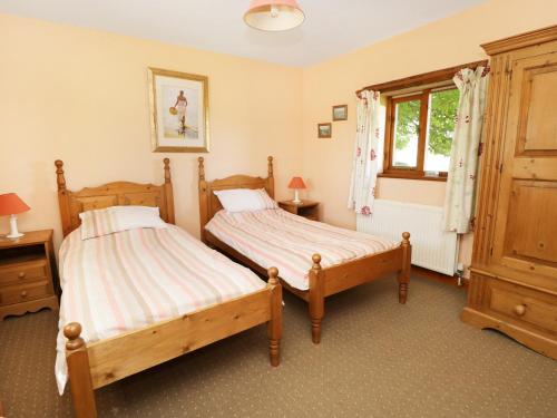 a bedroom with two beds and a window at Rose Cottage in Great Edston