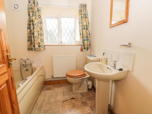 a bathroom with a sink and a toilet and a bath tub at Milton Cottage in Whitby