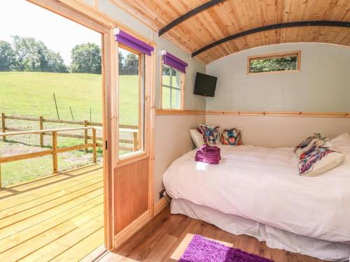 a bedroom with a bed and a large window at Railway Carriage in Abergavenny