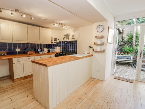 a kitchen with white cabinets and a counter top at Chwech in Menai Bridge