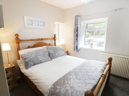 um quarto com uma cama e uma janela em Ty Coed em Llanberis