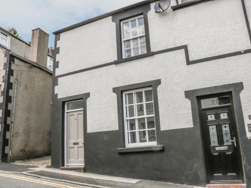 a white and black house on a street at 22 Uppergate Street in Conwy