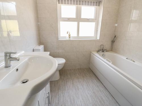 a bathroom with a sink and a tub and a toilet at 22 Uppergate Street in Conwy