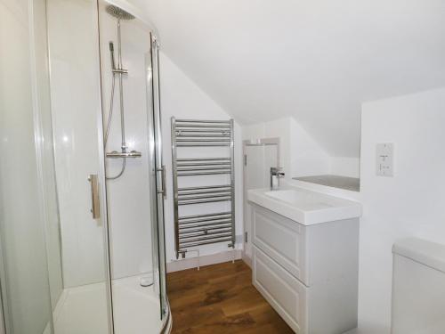 a white bathroom with a sink and a shower at Heron Lodge Castle Farm in Wedmore