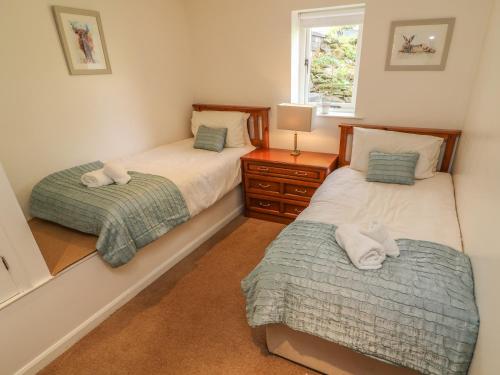 a bedroom with two beds and a window at Latterbarrow in Ambleside