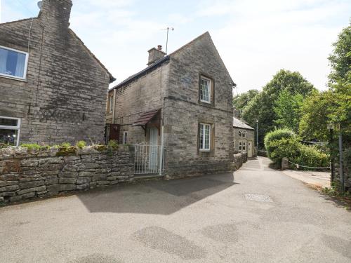 an old stone house with a stone wall at Mill Leat in Castleton