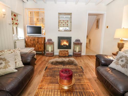 a living room with a couch and a fireplace at Mill Leat in Castleton