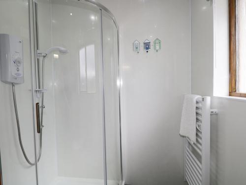een douche met een glazen deur in de badkamer bij The Ben in Leckmelm