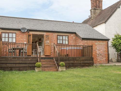 a brick house with a porch and a deck at Old Hall Barn 1 in Church Stretton