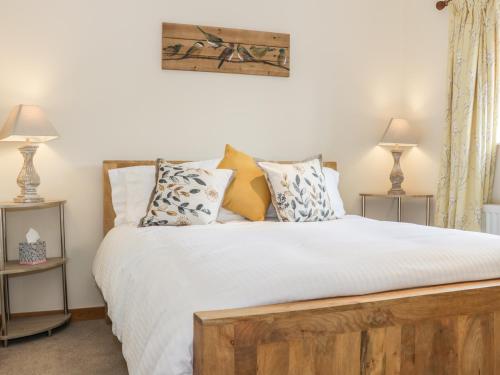 a bedroom with a large bed with white sheets and pillows at Old Hall Barn 1 in Church Stretton