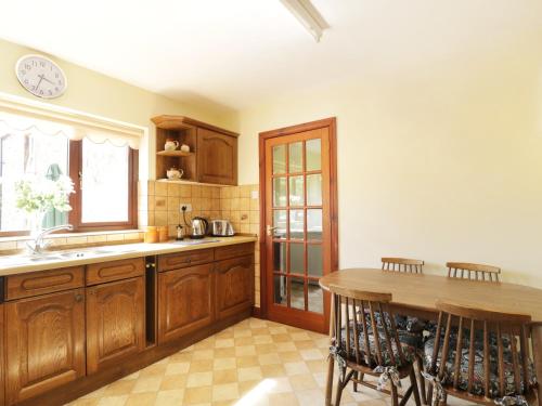 a kitchen with wooden cabinets and a wooden table at Acorns in Brampton
