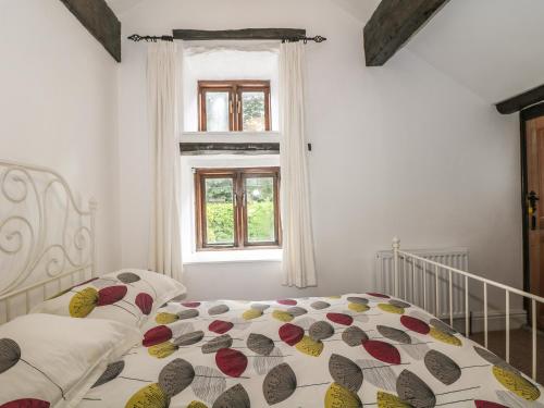 a bedroom with a bed and a window at Barn Cottage in Buxton