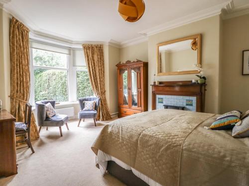 a bedroom with a bed and a mirror and a fireplace at The Garden Flat in Harrogate