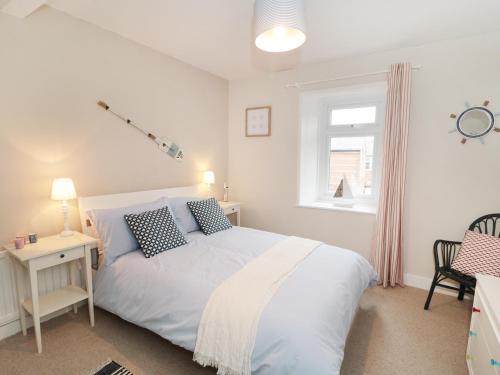 Un dormitorio con una cama blanca y una ventana. en Larksbay View, en Redcar