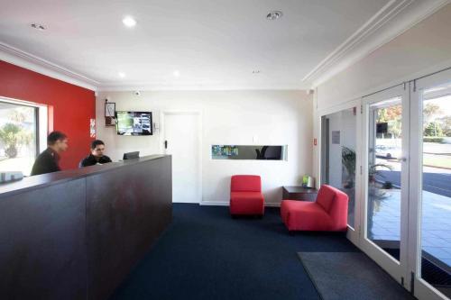 a living room filled with furniture and a large window at Auckland Airport Kiwi Motel in Auckland