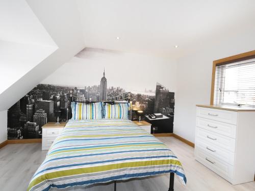 a bedroom with a large bed with a city view at Maclean Cottage in Beauly