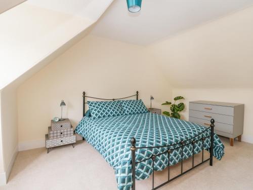 a bedroom with a bed with a blue comforter at Westwood in Ballater