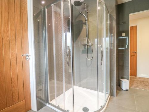 a shower with a glass door in a bathroom at Burnside Cottage in Portree