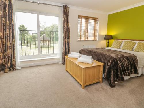 a bedroom with a bed and a large window at Dragonfly in Bridgwater