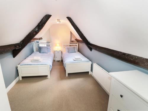 two beds in a attic bedroom with blue walls at Pear Tree House in Whitby