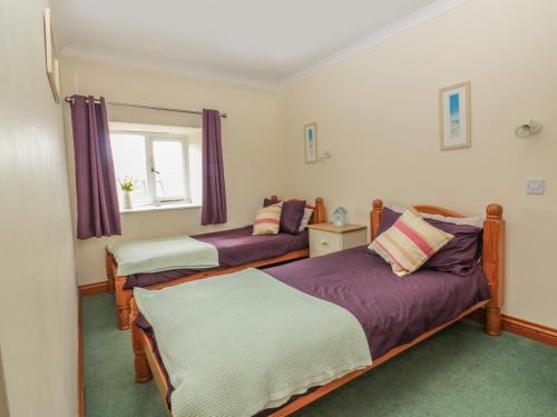 ein Schlafzimmer mit zwei Betten und einem Fenster in der Unterkunft Sorrel Cottage in Padstow