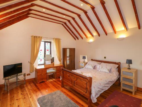 a bedroom with a bed and a flat screen tv at Riber View Barn in Chesterfield