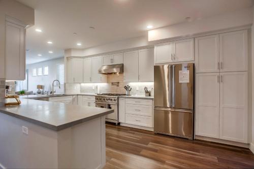 a kitchen with white cabinets and a stainless steel refrigerator at Opal Oasis in San Diego