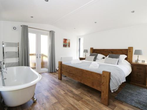 Schlafzimmer mit einem Bett und einer Badewanne in der Unterkunft Beech Tree Lodge in Skirpenbeck