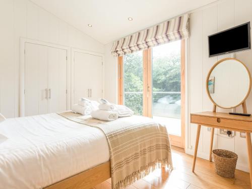 Un dormitorio con una cama y un espejo y una ventana. en 7 Water's Edge, en Looe