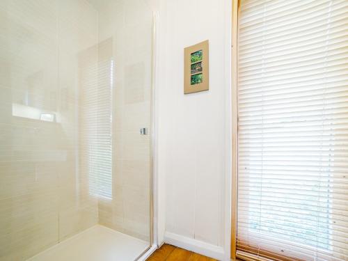 a shower with a glass door in a bathroom at 2 Water's Edge in Looe