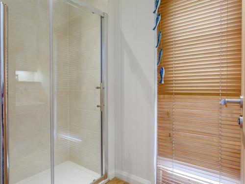 a shower with a glass door in a bathroom at 8 Streamside in Looe