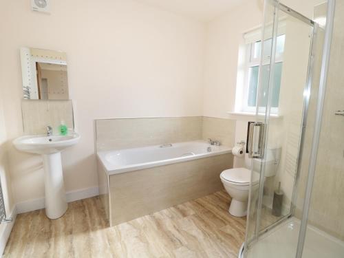a bathroom with a tub and a toilet and a sink at Breamish in Longframlington